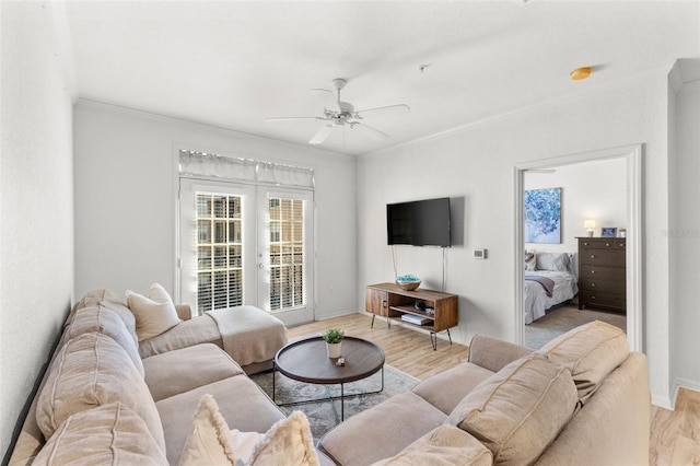 living room featuring ceiling fan, crown molding, and light hardwood / wood-style flooring