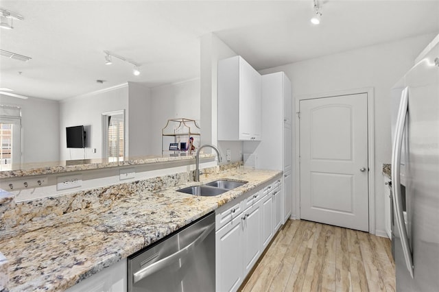 kitchen with appliances with stainless steel finishes, light wood-type flooring, rail lighting, sink, and white cabinets