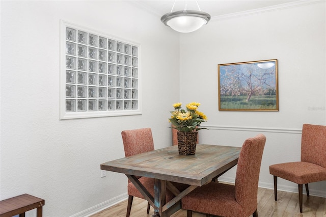 dining area featuring light hardwood / wood-style floors and crown molding