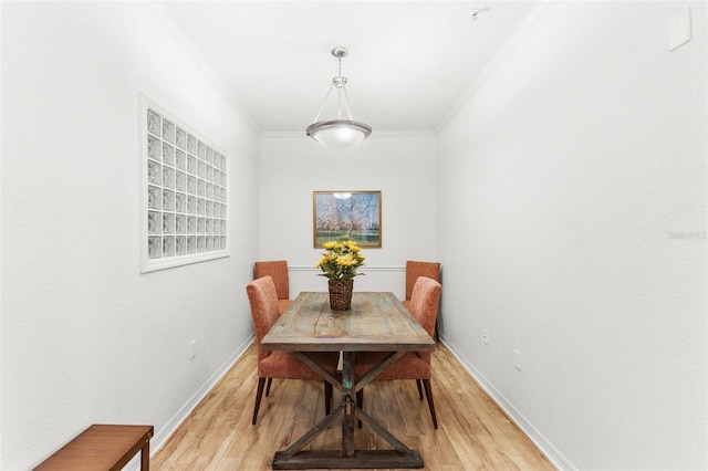 dining room with light wood-type flooring and ornamental molding