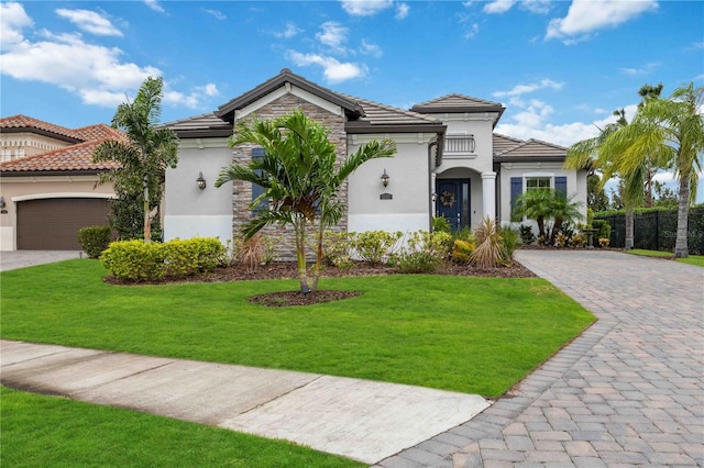 mediterranean / spanish-style house featuring a front yard and a garage