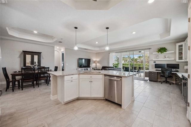 kitchen with a tray ceiling, stainless steel dishwasher, white cabinetry, and an island with sink