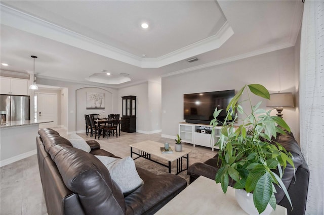 living room with a raised ceiling and crown molding