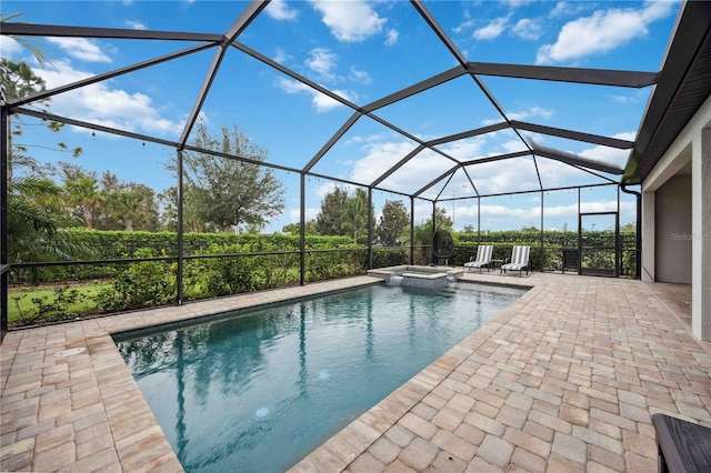 view of pool featuring glass enclosure, a patio area, and an in ground hot tub