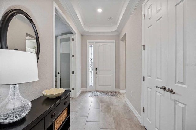 entrance foyer featuring a raised ceiling and crown molding