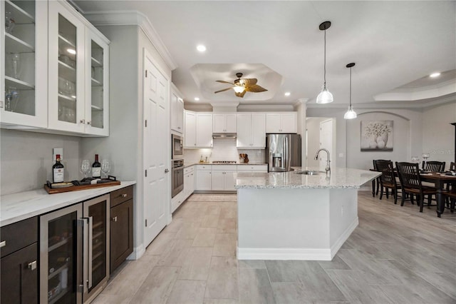 kitchen with pendant lighting, white cabinets, a raised ceiling, sink, and appliances with stainless steel finishes