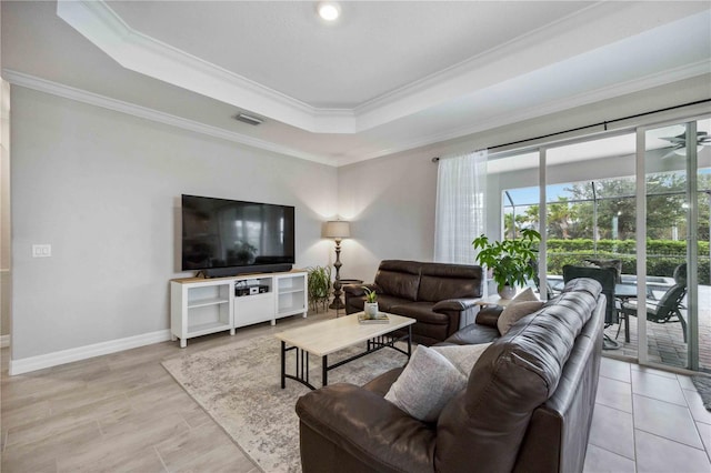 living room with ceiling fan, ornamental molding, and a tray ceiling