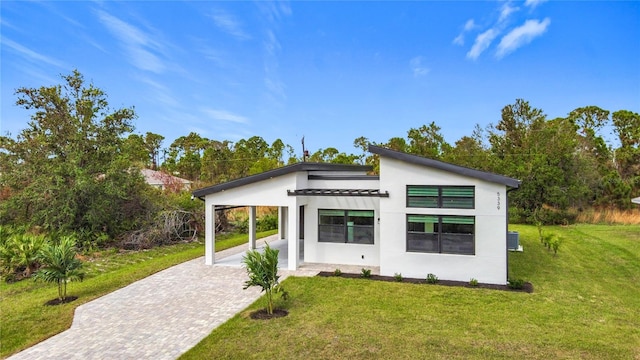 back of property featuring a carport and a lawn