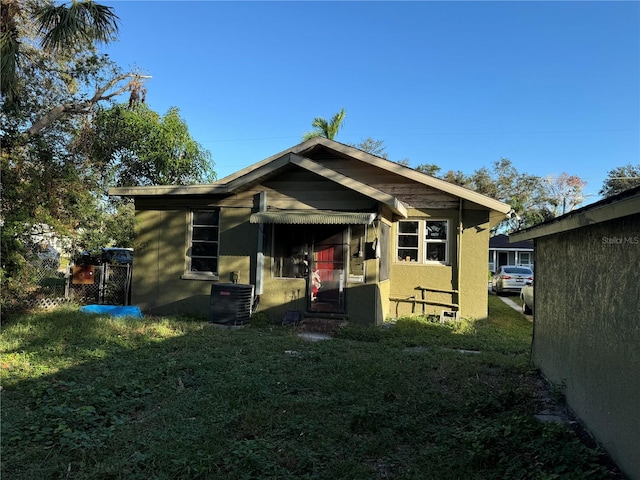 view of front of property featuring a front yard and central AC