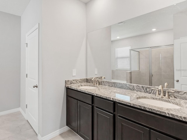 bathroom featuring vanity, tile patterned floors, and tiled shower