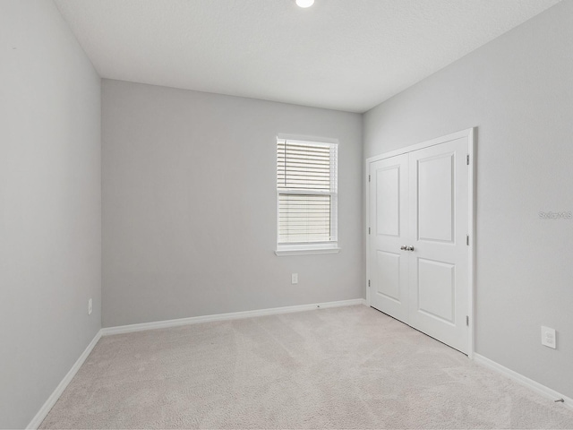 unfurnished bedroom featuring light carpet