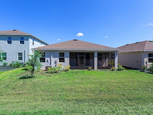 back of property with a yard and a sunroom