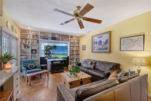 living room with a textured ceiling and light wood-type flooring