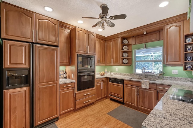 kitchen featuring light stone countertops, black appliances, a textured ceiling, light hardwood / wood-style floors, and ceiling fan