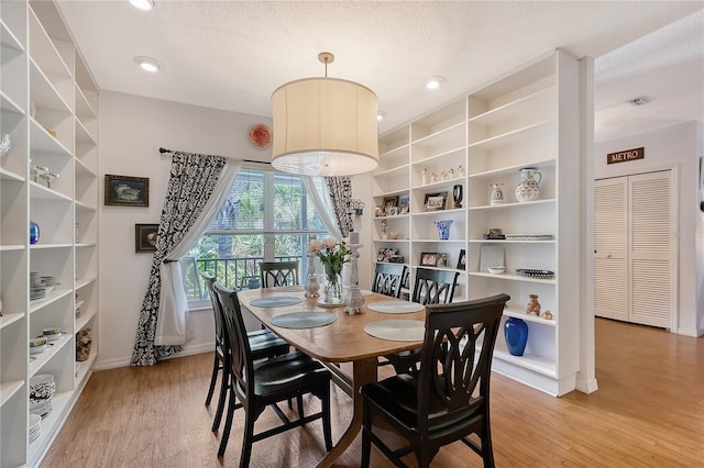 dining area with a textured ceiling and wood-type flooring