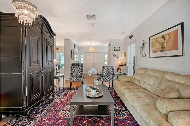 living room featuring dark wood-type flooring and a chandelier