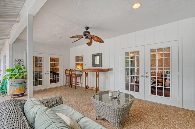 living room featuring french doors, a textured ceiling, and ceiling fan