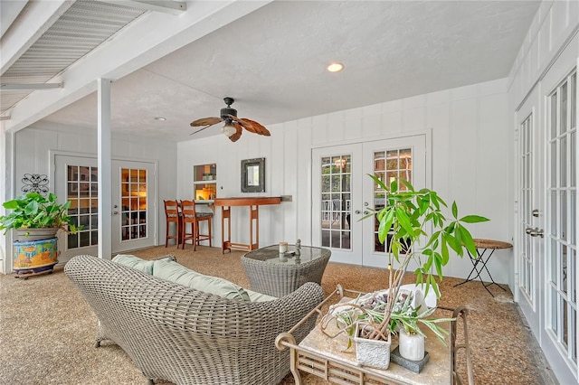 sunroom / solarium featuring french doors, beam ceiling, and ceiling fan