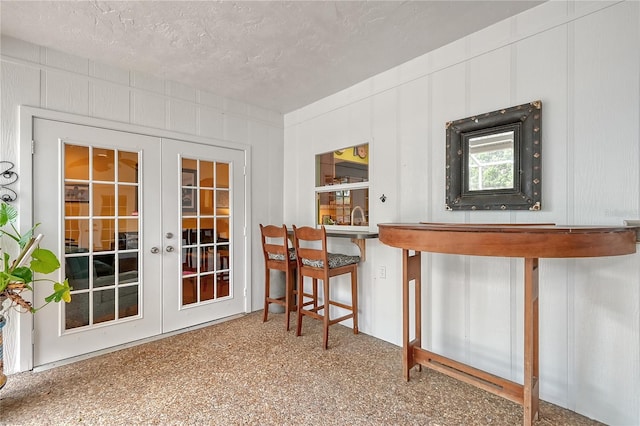 interior space featuring french doors and a textured ceiling