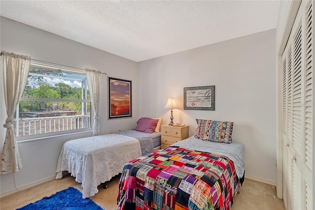 bedroom featuring light carpet, a closet, and a textured ceiling