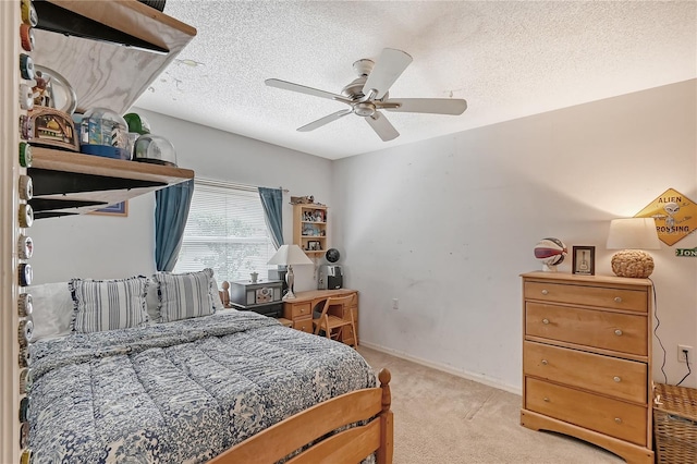 bedroom with ceiling fan, light carpet, and a textured ceiling