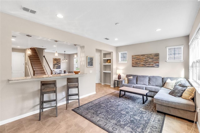 living room with built in features and an inviting chandelier