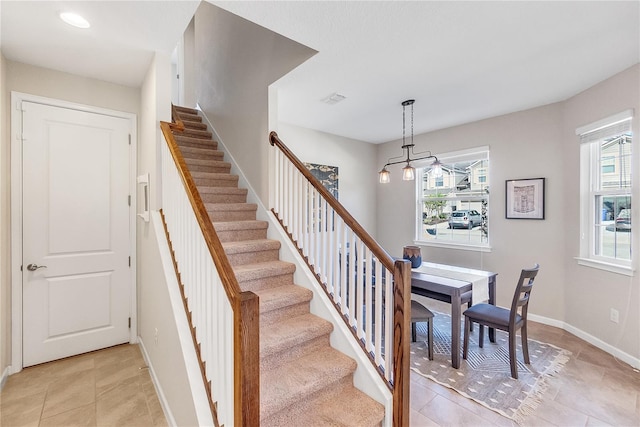 stairway featuring tile patterned flooring and plenty of natural light