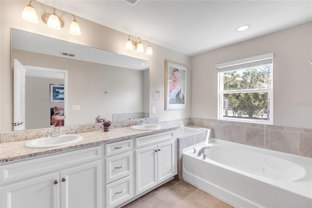 bathroom with vanity, a bathtub, and tile patterned flooring