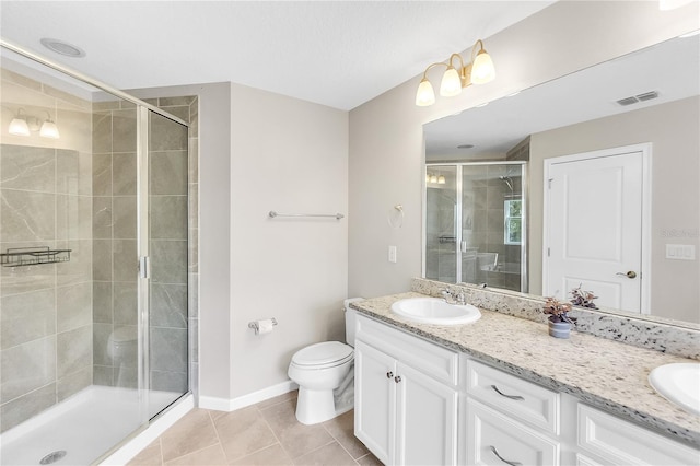 bathroom with vanity, a shower with shower door, toilet, and tile patterned floors