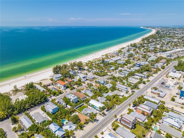 birds eye view of property with a water view and a beach view