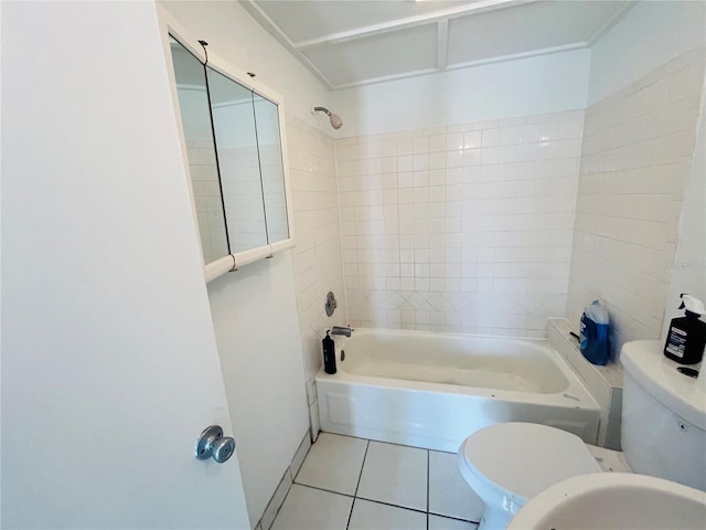 bathroom with tile patterned floors, tiled shower / bath combo, and toilet