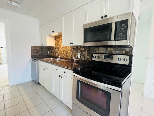 kitchen with sink, appliances with stainless steel finishes, white cabinetry, and tasteful backsplash