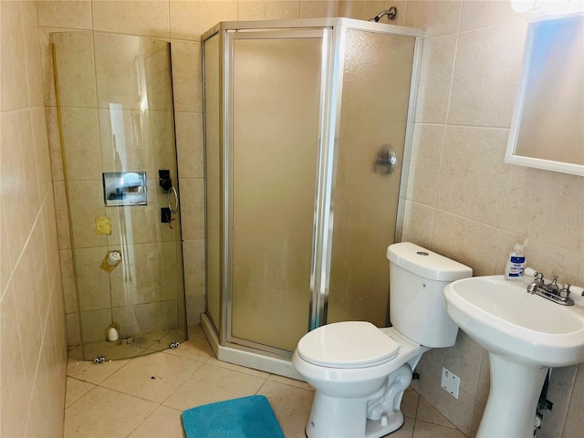 bathroom with toilet, tile patterned floors, tile walls, and an enclosed shower