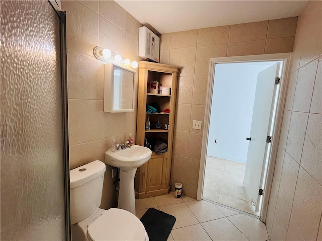 bathroom featuring toilet, walk in shower, tile patterned floors, and tile walls