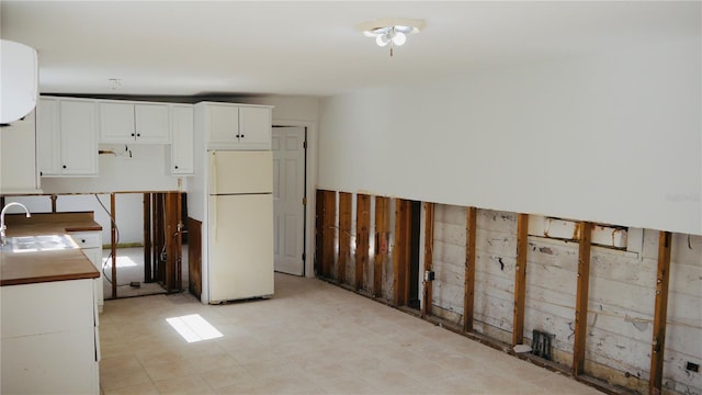 kitchen featuring sink, white cabinets, and white refrigerator