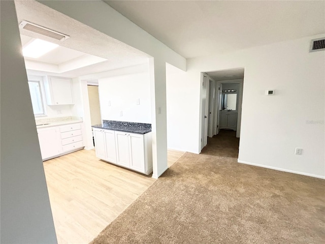 kitchen featuring white cabinets and light wood-type flooring