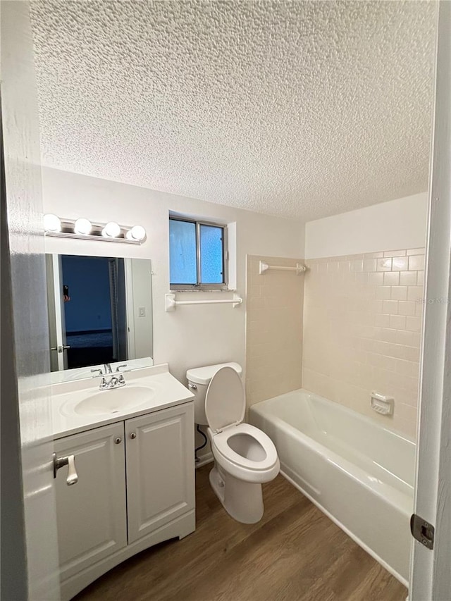 full bathroom featuring a textured ceiling, wood-type flooring, toilet, vanity, and shower / bath combination