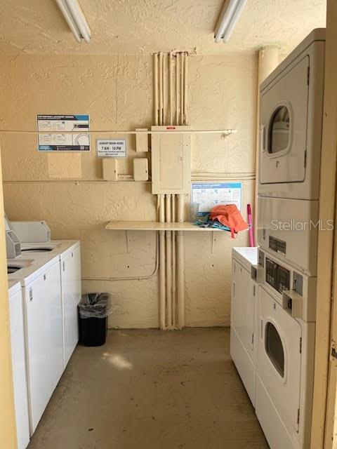 clothes washing area with stacked washer and clothes dryer and washing machine and clothes dryer