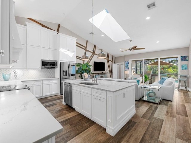 kitchen featuring white cabinetry, pendant lighting, dark hardwood / wood-style flooring, and an island with sink