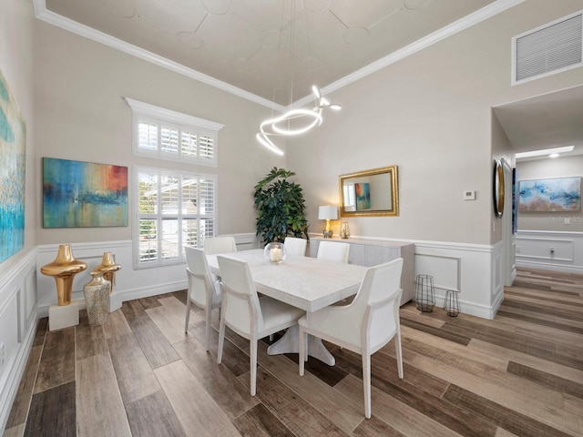 dining room with ornamental molding and hardwood / wood-style flooring