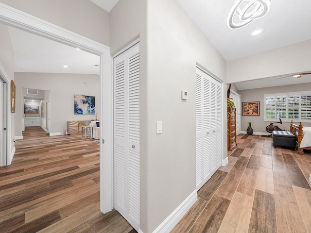 hall featuring lofted ceiling and hardwood / wood-style flooring