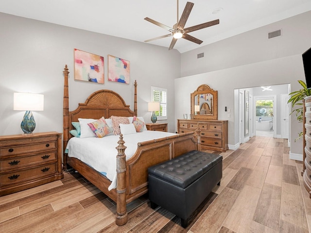 bedroom featuring ceiling fan, wood-type flooring, multiple windows, and ensuite bathroom