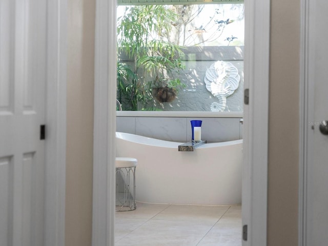 bathroom featuring tile patterned floors, a tub to relax in, and plenty of natural light