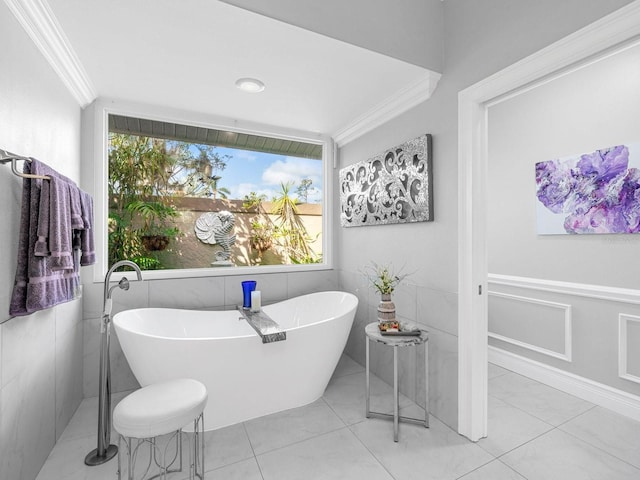 bathroom with ornamental molding, a tub to relax in, tile patterned floors, and tile walls