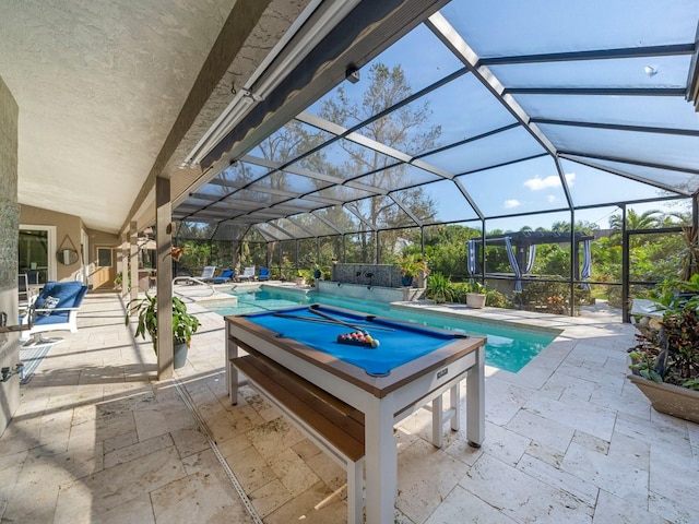 view of swimming pool with a patio, glass enclosure, and a jacuzzi