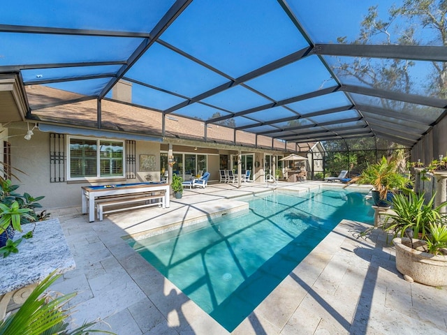 view of pool with a patio area and glass enclosure