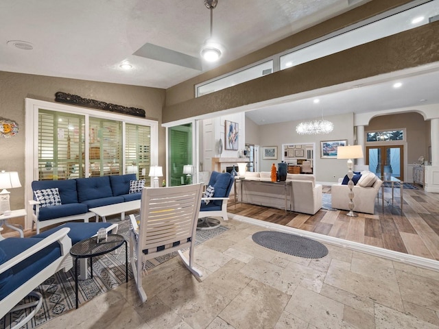 living room featuring light hardwood / wood-style flooring, a healthy amount of sunlight, and a notable chandelier