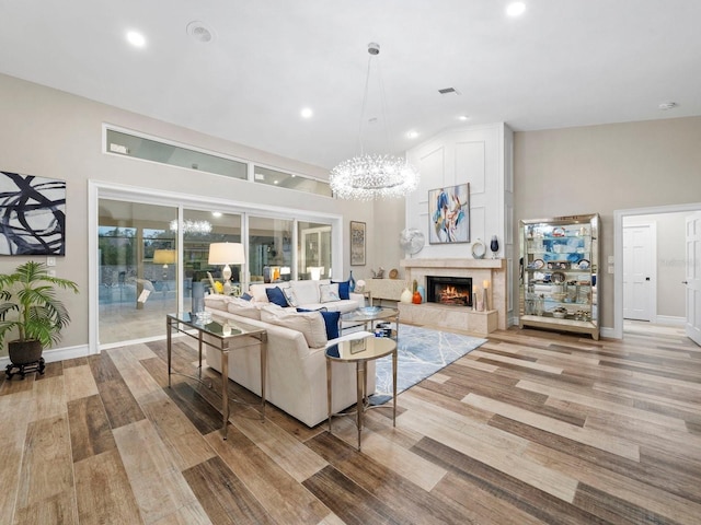 living room with light hardwood / wood-style flooring, a chandelier, and a fireplace