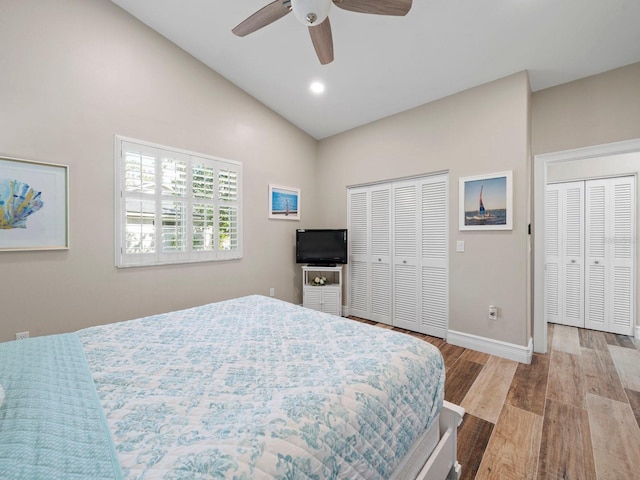 bedroom with ceiling fan, vaulted ceiling, and light hardwood / wood-style floors