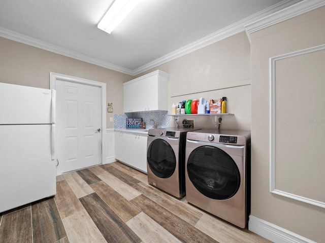 laundry area with cabinets, separate washer and dryer, light hardwood / wood-style floors, crown molding, and sink